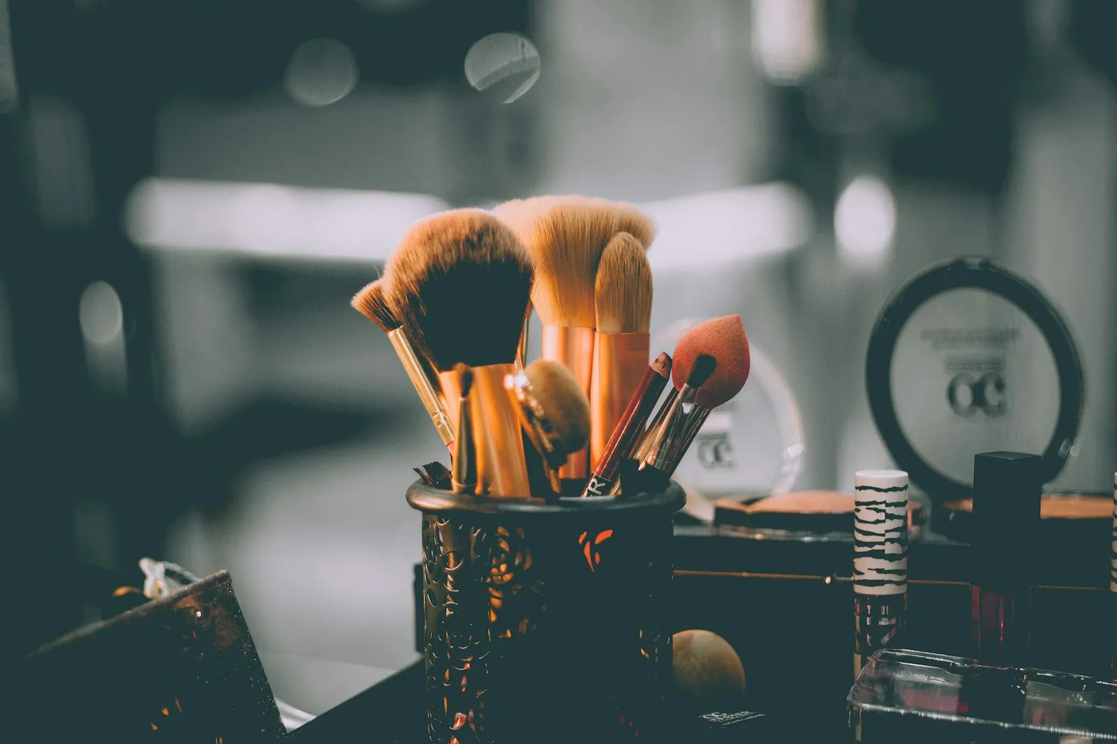 Makeup brushes in a holder on a vanity, part of the Alaikas.com makeup essentials kit