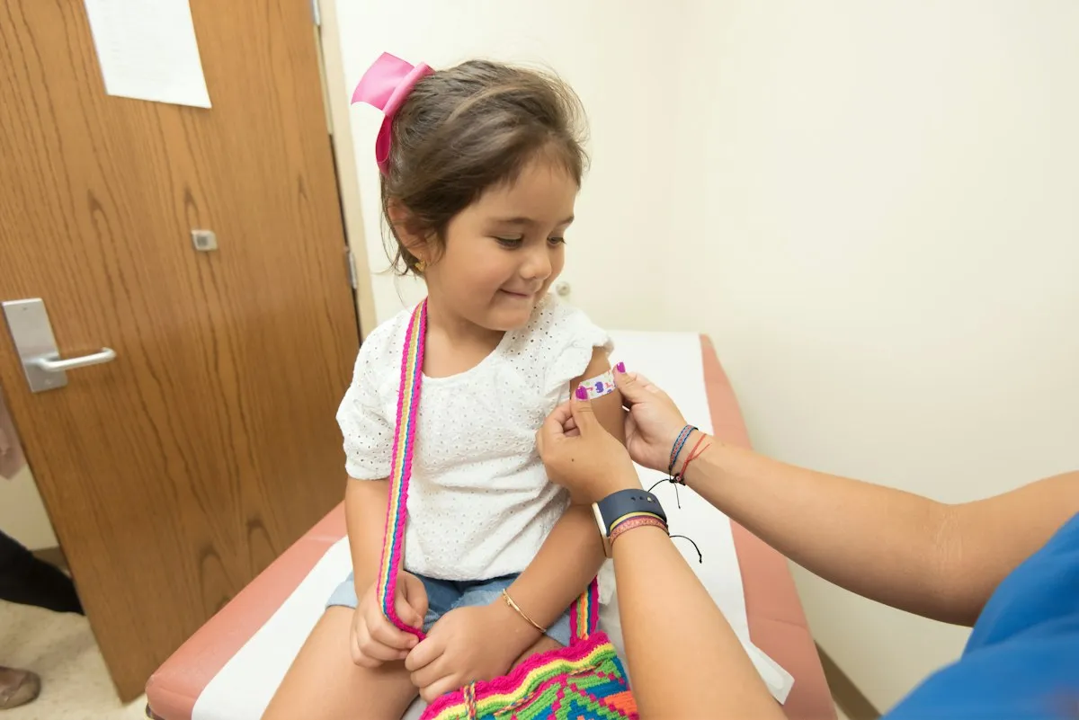 Young girl receiving a vaccine in her upper arm during a pediatric checkup