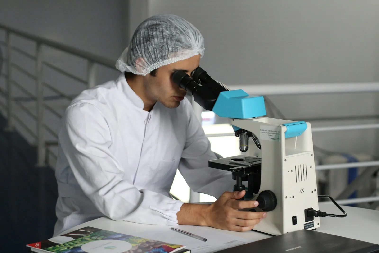 Laboratory scientist examining a sample through a microscope in a hospital clinical laboratory