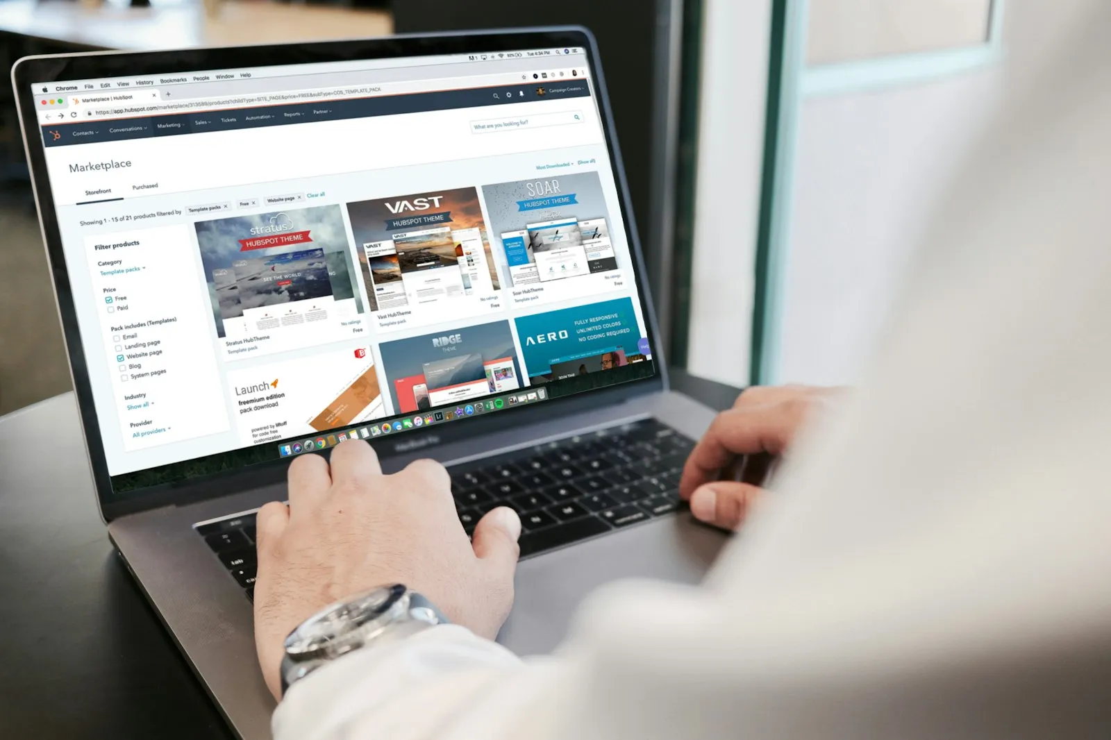 Person browsing product listings on a laptop, showing how the alaikas.com hybrid marketplace works